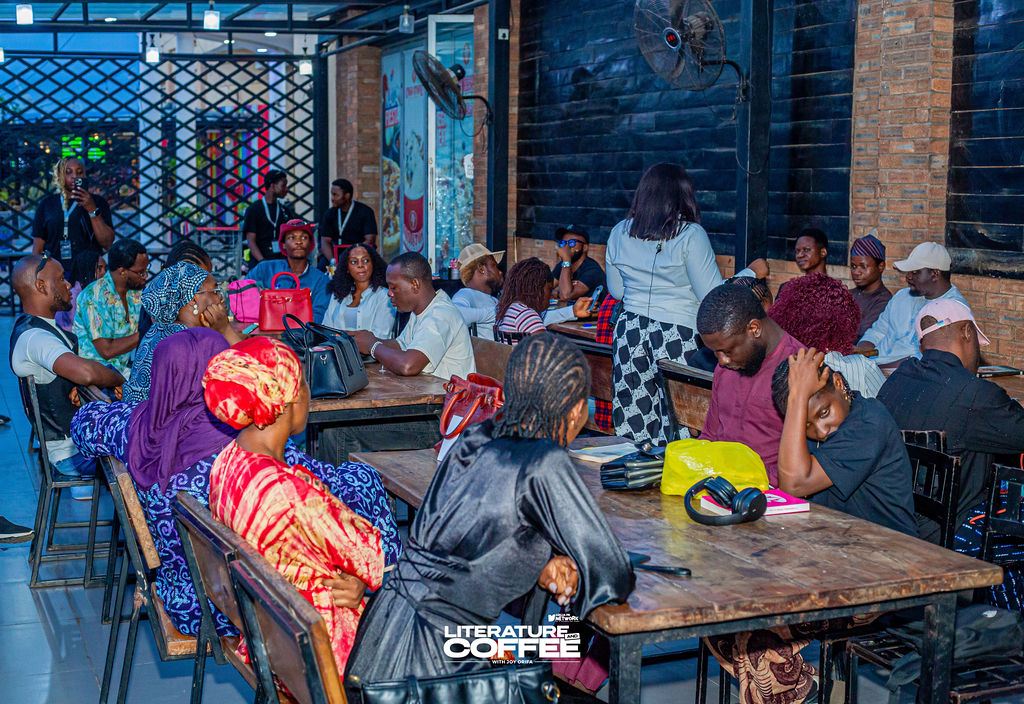 Wide view of a café full of guests seated at long tables.